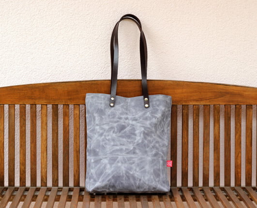 light gray waxed bag with leather strap